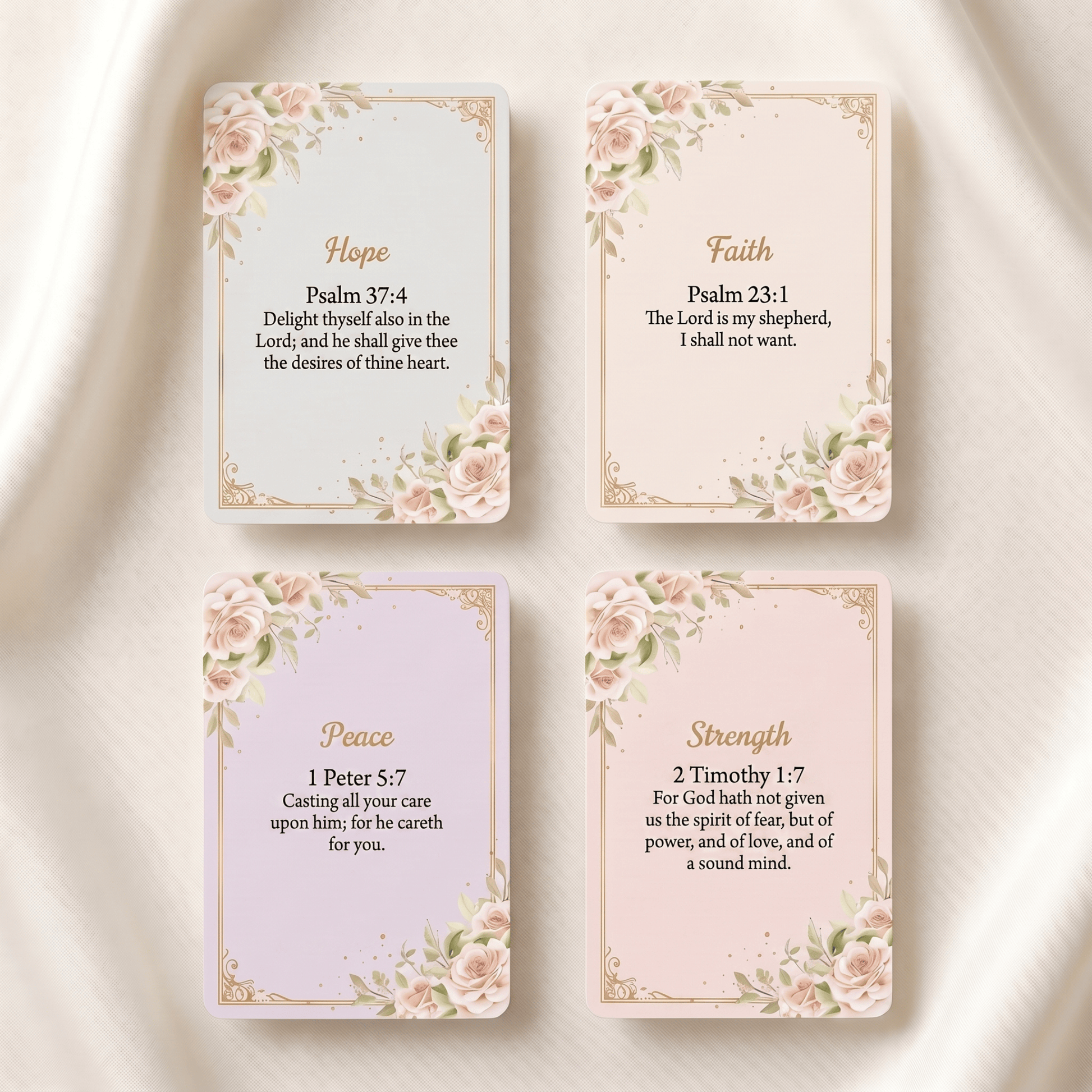 Four decorative cards arranged in a 2x2 grid on a soft white fabric background. The cards feature floral corner designs and gold borders, with the words Hope, Faith, Peace, and Strength at the top, and Bible verse text below.